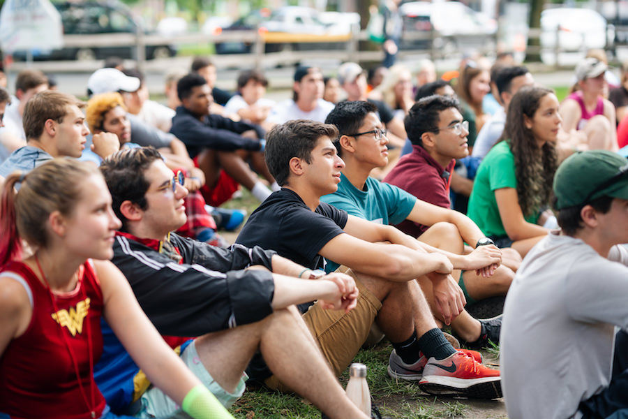 Students sit on the lawn in front of Robinson Hall during First-Year Trips.